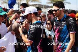 (L to R): Esteban Ocon (FRA) Alpine F1 Team and Pierre Gasly (FRA) Alpine F1 Team with fans. 02.03.2024. Formula 1 World Championship, Rd 1, Bahrain Grand Prix, Sakhir, Bahrain, Race Day.